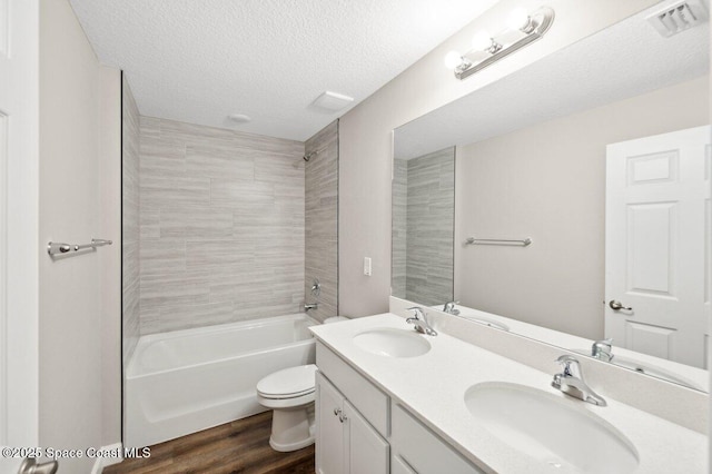 1011 Webster Rd SE, Palm Bay, FL 32909 - full bath with double vanity, wood finished floors, washtub / shower combination, and a textured ceiling