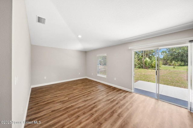 1011 Webster Rd SE, Palm Bay, FL 32909 - empty room with wood finished floors, vaulted ceiling, and recessed lighting