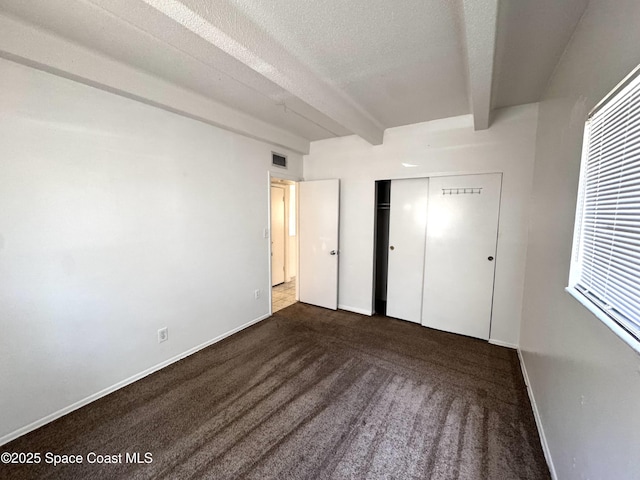 1715 Dixon Blvd Unit 102, Cocoa, FL 32922 - unfurnished bedroom with beamed ceiling, carpet flooring, a closet, and a textured ceiling