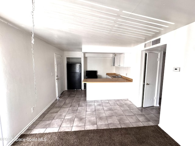 1721 Dixon Blvd Unit 36, Cocoa, FL 32922 - kitchen featuring freestanding refrigerator, light tile patterned flooring, a peninsula, and white cabinets