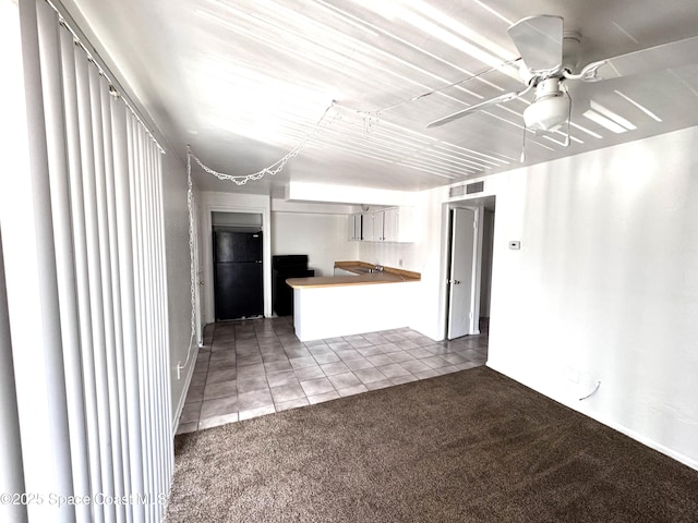 1721 Dixon Blvd Unit 36, Cocoa, FL 32922 - kitchen with freestanding refrigerator, carpet flooring, tile patterned floors, a peninsula, and a ceiling fan