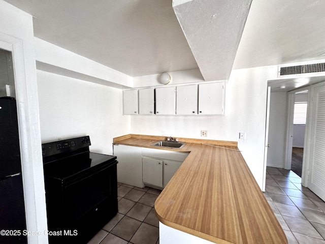 1721 Dixon Blvd Unit 36, Cocoa, FL 32922 - kitchen with black appliances, light tile patterned floors, white cabinets, and butcher block countertops