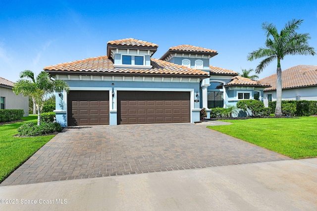 5197 Kirkwall Cir, Melbourne, FL 32940 - mediterranean / spanish house featuring a garage, driveway, a front yard, a tiled roof, and stucco siding