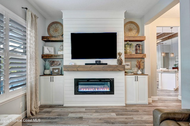 5197 Kirkwall Cir, Melbourne, FL 32940 - living area with wood finished floors, a glass covered fireplace, and healthy amount of natural light