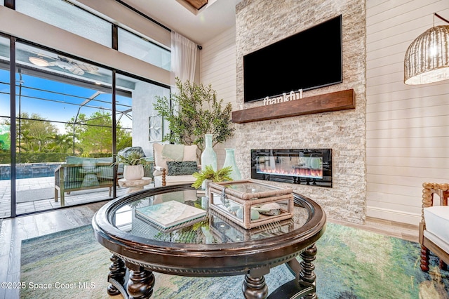 5197 Kirkwall Cir, Melbourne, FL 32940 - living area featuring wood finished floors, a high ceiling, wood walls, and a glass covered fireplace