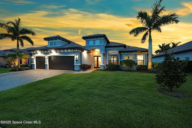 5197 Kirkwall Cir, Melbourne, FL 32940 - mediterranean / spanish-style house featuring a garage, a lawn, decorative driveway, and a tile roof