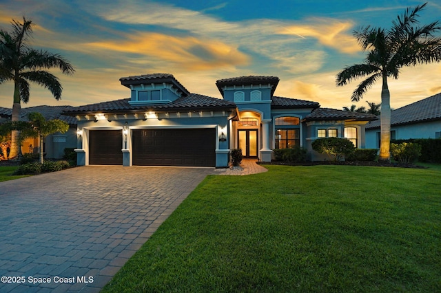 5197 Kirkwall Cir, Melbourne, FL 32940 - mediterranean / spanish home with a tile roof, a garage, decorative driveway, a front lawn, and stucco siding