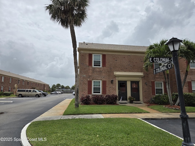 152 E Colonial Ct Unit 84, Indian Harbour Beach, FL 32937 - townhome / multi-family property featuring brick siding, uncovered parking, and a front yard