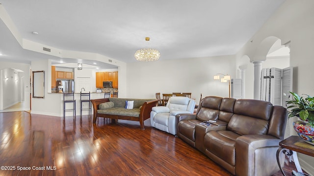 420 Moore Park Ln Unit 203, Merritt Island, FL 32952 - living area with arched walkways, wood finished floors, a chandelier, and decorative columns