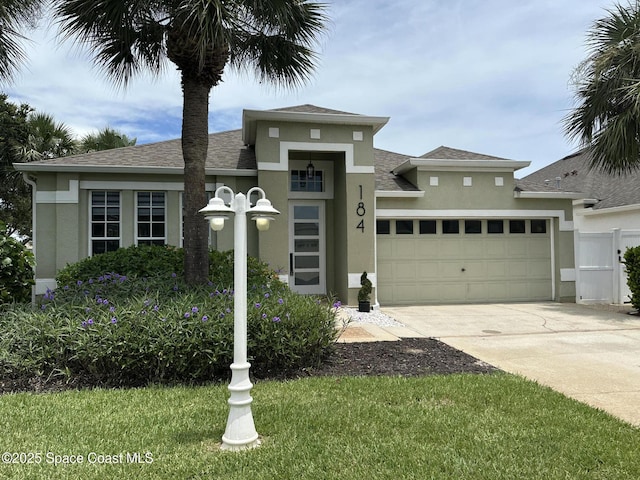 184 Calico Ln, Indialantic, FL 32903 - view of front of house featuring stucco siding, an attached garage, concrete driveway, and a shingled roof