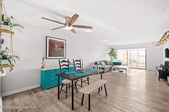1611 Minutemen Cswy Unit 107-Hh, Cocoa Beach, FL 32931 - dining room featuring light wood-style floors, a textured ceiling, and ceiling fan