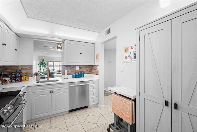 1611 Minutemen Cswy Unit 107-Hh, Cocoa Beach, FL 32931 - kitchen featuring appliances with stainless steel finishes, a textured ceiling, backsplash, white cabinets, and light countertops