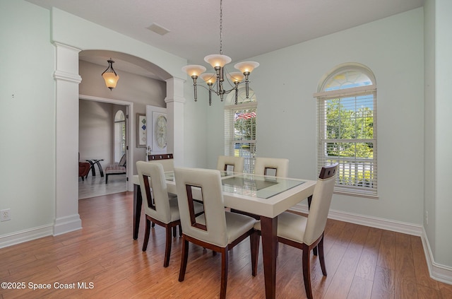 2351 Stonebridge Dr, Rockledge, FL 32955 - dining room featuring arched walkways, a chandelier, and light wood finished floors