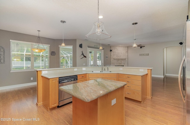 2351 Stonebridge Dr, Rockledge, FL 32955 - kitchen featuring appliances with stainless steel finishes, a center island, light wood-type flooring, light brown cabinets, and a textured ceiling