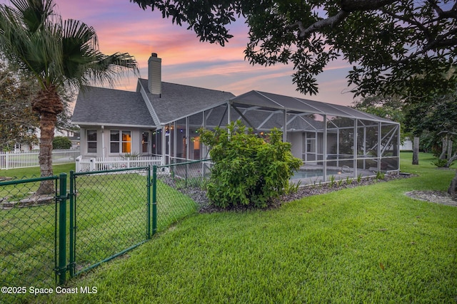 2351 Stonebridge Dr, Rockledge, FL 32955 - rear view of house featuring a gate, roof with shingles, a chimney, and a lanai
