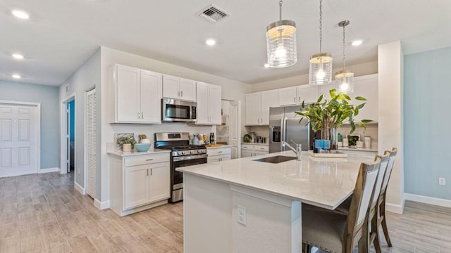 1997 Fuchsia Pl NW, Palm Bay, FL 32907 - kitchen featuring stainless steel appliances, white cabinetry, light wood-style floors, and recessed lighting