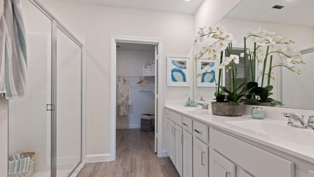 1997 Fuchsia Pl NW, Palm Bay, FL 32907 - bathroom with a stall shower, wood finished floors, double vanity, and a walk in closet