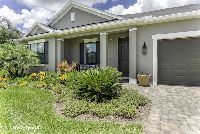 3975 Archdale St, Melbourne, FL 32940 - property entrance with stucco siding, covered porch, and an attached garage