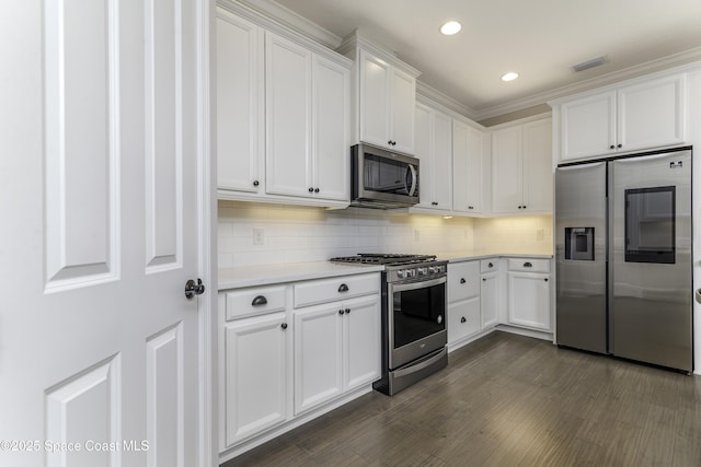 3975 Archdale St, Melbourne, FL 32940 - kitchen featuring appliances with stainless steel finishes, light countertops, recessed lighting, white cabinets, and crown molding