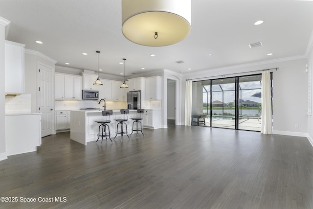 3975 Archdale St, Melbourne, FL 32940 - kitchen with stainless steel appliances, an island with sink, a breakfast bar, tasteful backsplash, and crown molding