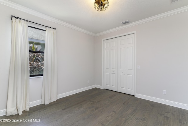 3975 Archdale St, Melbourne, FL 32940 - unfurnished bedroom with dark wood-style floors, crown molding, and a closet