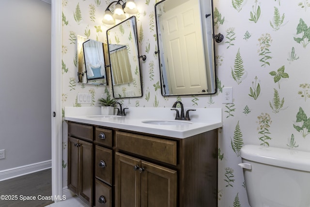 3975 Archdale St, Melbourne, FL 32940 - bathroom with wallpapered walls, double vanity, and wood finished floors