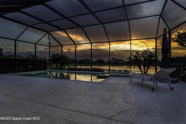 3975 Archdale St, Melbourne, FL 32940 - pool at dusk with a patio, a pool with connected hot tub, and glass enclosure