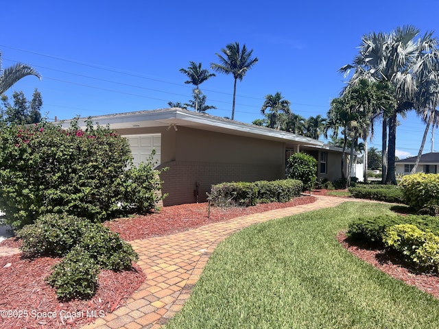 704 Malibu Ln, Indialantic, FL 32903 - view of home's exterior with a yard, brick siding, and stucco siding