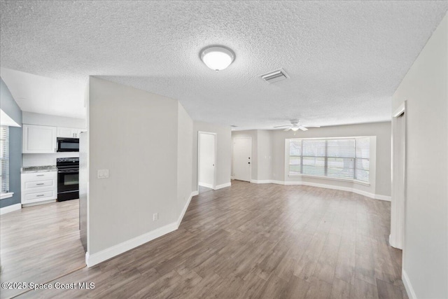 1871 Talloak Rd, Melbourne, FL 32935 - unfurnished living room with a ceiling fan, light wood finished floors, and a textured ceiling