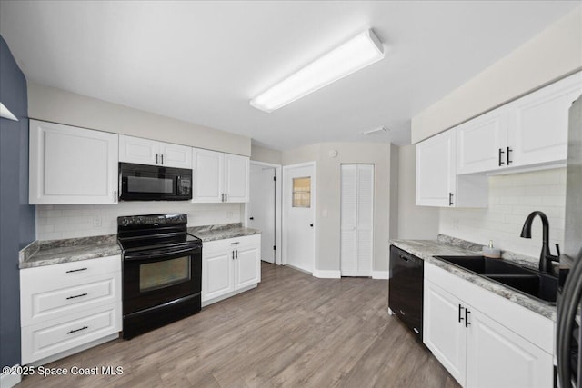 1871 Talloak Rd, Melbourne, FL 32935 - kitchen with black appliances, decorative backsplash, white cabinets, and light countertops