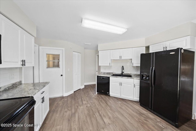 1871 Talloak Rd, Melbourne, FL 32935 - kitchen featuring black appliances, tasteful backsplash, white cabinetry, and light wood-type flooring