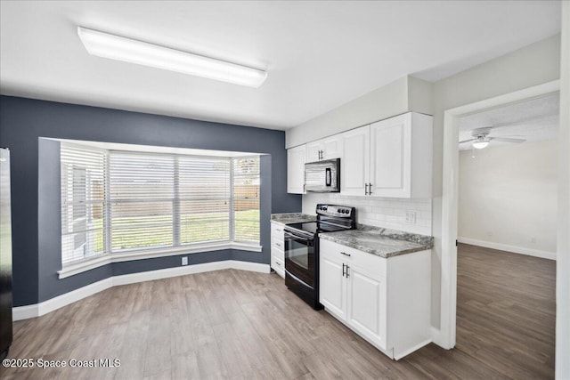 1871 Talloak Rd, Melbourne, FL 32935 - kitchen featuring black appliances, plenty of natural light, and wood finished floors