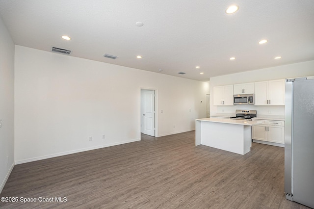 1889 Warton Ave SE, Palm Bay, FL 32909 - kitchen with appliances with stainless steel finishes, wood finished floors, recessed lighting, white cabinets, and light countertops