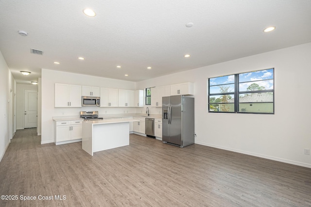 1889 Warton Ave SE, Palm Bay, FL 32909 - kitchen with stainless steel appliances, light wood-type flooring, a center island, light countertops, and recessed lighting