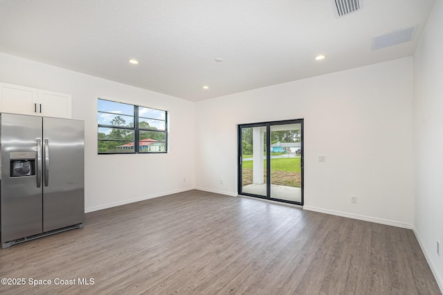 1889 Warton Ave SE, Palm Bay, FL 32909 - spare room featuring light wood-type flooring, healthy amount of natural light, and recessed lighting
