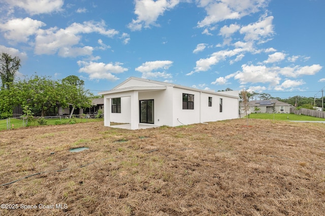 1889 Warton Ave SE, Palm Bay, FL 32909 - rear view of property with stucco siding and a patio