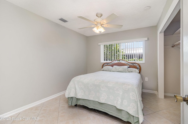 714 Catalina Rd Unit 2, Cocoa Beach, FL 32931 - bedroom with light tile patterned flooring, a ceiling fan, a textured ceiling, and a closet