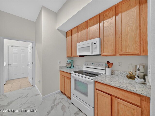 4086 Meander Pl Unit 104, Rockledge, FL 32955 - kitchen featuring white appliances, light marble finish flooring, and light stone countertops