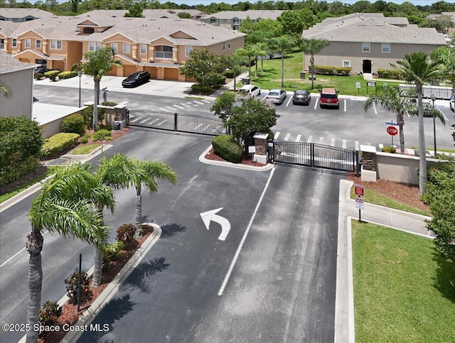 4086 Meander Pl Unit 104, Rockledge, FL 32955 - view of asphalt road with a gate, a residential view, traffic signs, and curbs
