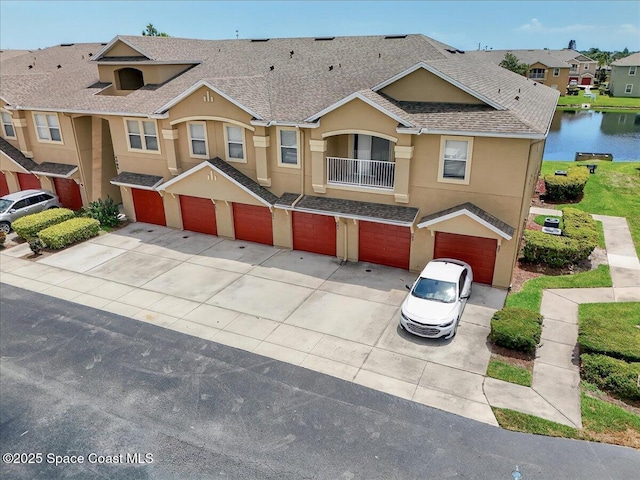 4086 Meander Pl Unit 104, Rockledge, FL 32955 - multi unit property featuring driveway, stucco siding, a garage, a shingled roof, and a water view