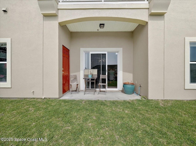 4086 Meander Pl Unit 104, Rockledge, FL 32955 - view of exterior entry featuring a yard, a patio, and stucco siding