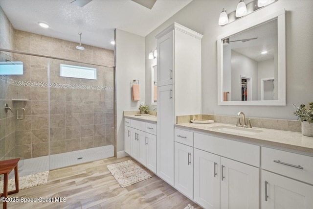 4692 Shannock Ave, Merritt Island, FL 32953 - bathroom with double vanity, a stall shower, wood finished floors, and a walk in closet