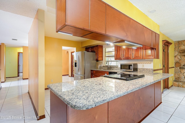 755 Haftez St NE, Palm Bay, FL 32907 - kitchen with appliances with stainless steel finishes, light stone countertops, a peninsula, light tile patterned floors, and a textured ceiling