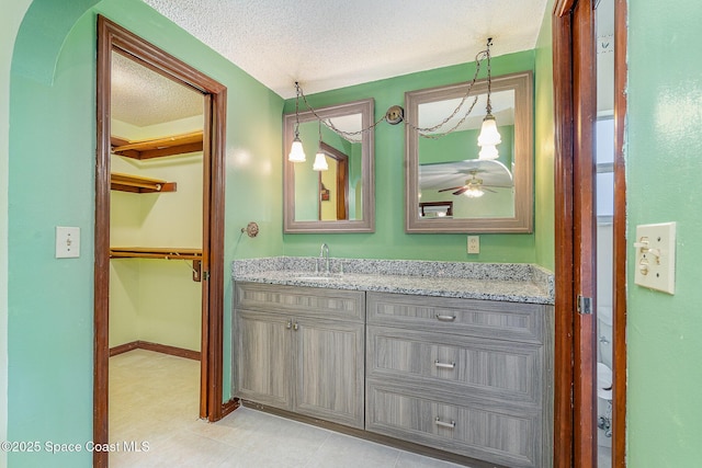 755 Haftez St NE, Palm Bay, FL 32907 - bathroom with vanity, a textured ceiling, ceiling fan, and a spacious closet