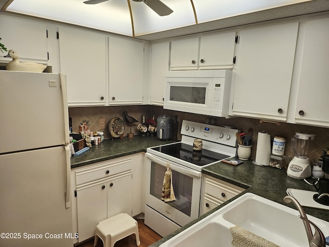 997 Sonesta Ave NE Unit 202, Palm Bay, FL 32905 - kitchen with white appliances, decorative backsplash, a ceiling fan, dark countertops, and white cabinets