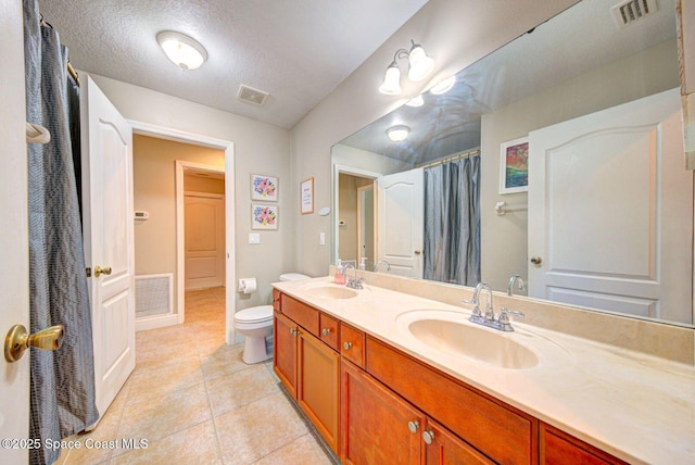 4082 Brantley Cir, Rockledge, FL 32955 - bathroom featuring double vanity, tile patterned floors, a textured ceiling, and a shower with shower curtain