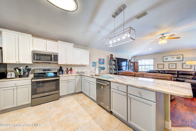 4082 Brantley Cir, Rockledge, FL 32955 - kitchen with stainless steel appliances, a peninsula, a ceiling fan, open floor plan, and pendant lighting
