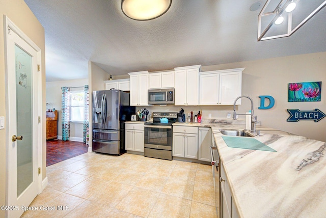 4082 Brantley Cir, Rockledge, FL 32955 - kitchen featuring appliances with stainless steel finishes, light countertops, white cabinets, light tile patterned flooring, and a textured ceiling