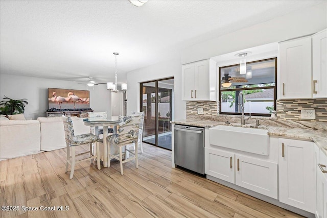 380 Cherry Ct, Satellite Beach, FL 32937 - kitchen with stainless steel dishwasher, a ceiling fan, tasteful backsplash, and white cabinetry