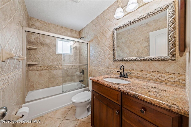 380 Cherry Ct, Satellite Beach, FL 32937 - bathroom featuring tile walls, vanity, tile patterned flooring, bath / shower combo with glass door, and tasteful backsplash